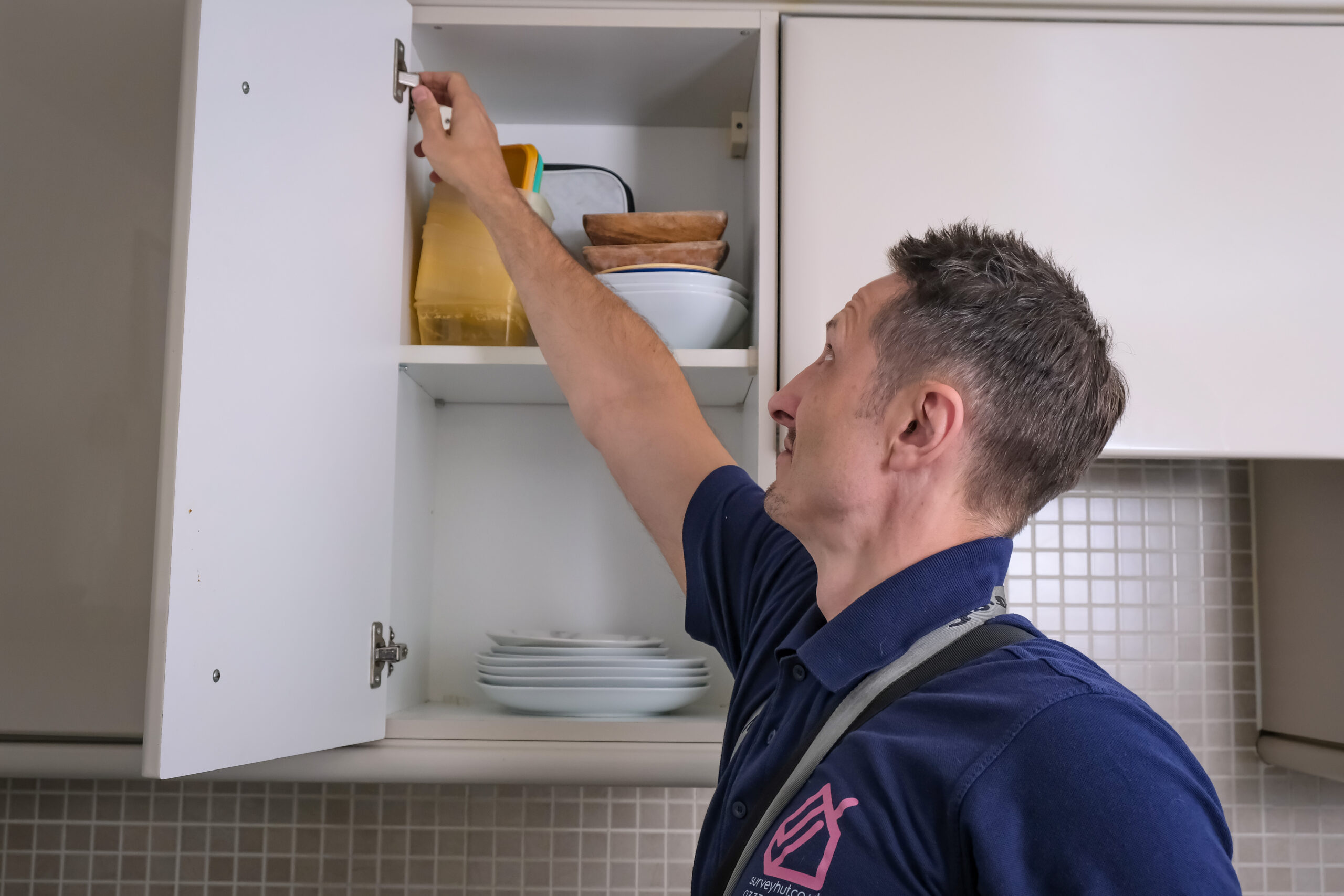 Surveyor checking cupboard