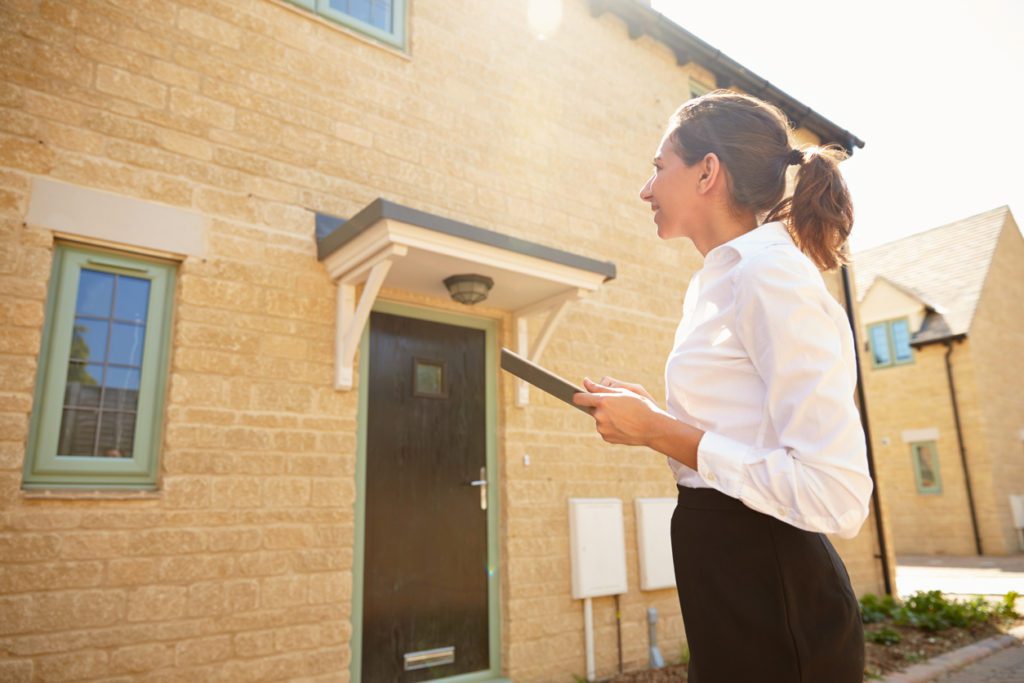 Female real estate agent looking at a house exterior