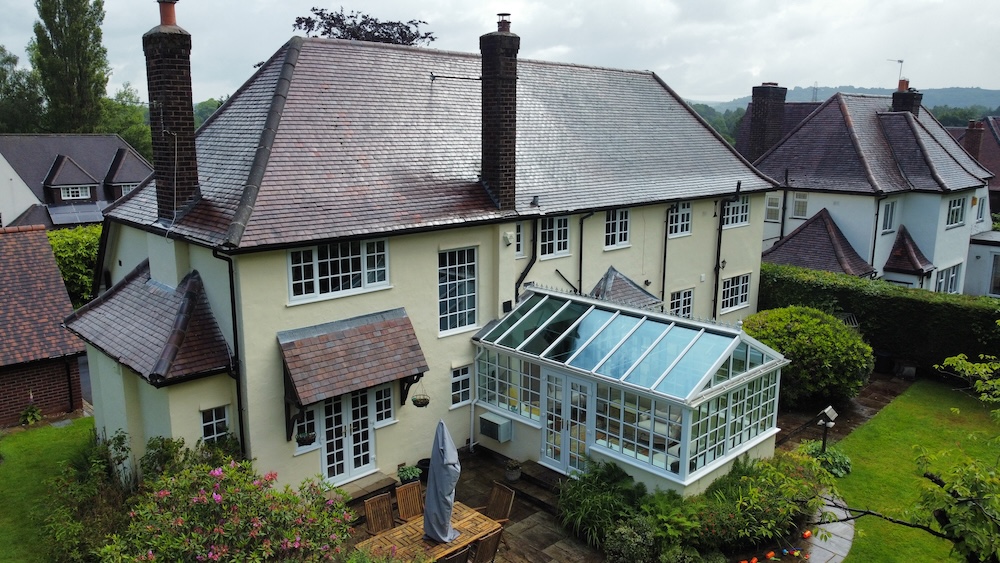 An aerial photo of a large detached house, featuring a conservatory.